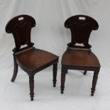 A pair of Victorian mahogany hall chairs,