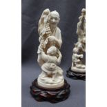A 19th century Japanese carved ivory figure group of a man and child with bunches of grapes on a