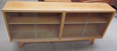 A mid 20th century light oak bookcase with glazed doors on splayed legs
