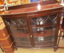 A 20th century mahogany display cabinet with a pair of glazed doors with glazing bars