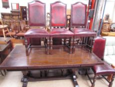 An oak extending dining table with a rectangular top and pull out leaves on cup and cover legs