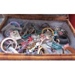 A picnic basket containing assorted costume jewellery including necklaces, bracelets,