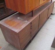 A large mid 20th century dark teak sideboard with a bank of five drawers and two cupboards on