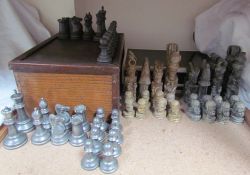 A base metal chess set contained in a fitted oak box together with an African carved stone chess