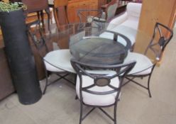 A metal and tiled dining table and four chairs together with a black painted terracotta pipe