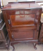 A mahogany side cabinet with a rectangular moulded top above two panelled cupboards on cabriole