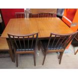 A teak extending dining table together with four chairs and a sideboard