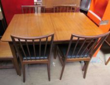 A teak extending dining table together with four chairs and a sideboard