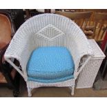 A rattan elbow chair painted white together with a laundry basket