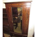 An early 20th century single door wardrobe with a drawer to the base