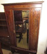 An early 20th century single door wardrobe with a drawer to the base