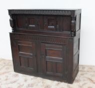 An 18th century oak court cupboard, the planked top above a carved frieze and turned columns,