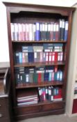 A modern bookcase with drawers to the base