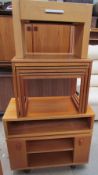 A teak television cabinet together with a nest of three teak tables and an oak bedside cabinet