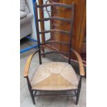 A late 19th century ladder back elbow chair with a rush seat on tapering legs