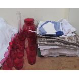 A cranberry glass jug together with cranberry glass glasses,