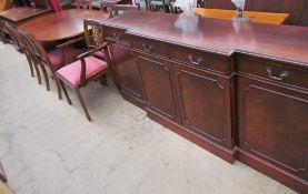 A reproduction mahogany extending dining table together with six chairs and a sideboard