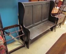 A 20th century oak settle together with a six division umbrella stand and a Sutherland table