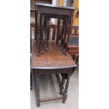 A 20th century oak gate leg dining table with a fan carved top on ring turned legs united by