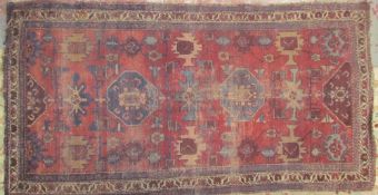 A red ground rug with four medallions and stylised flower heads together with a large rug with