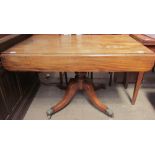 A Regency mahogany sofa table with a rectangular top and drop flaps on a turned column and four