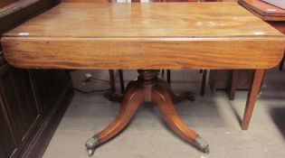 A Regency mahogany sofa table with a rectangular top and drop flaps on a turned column and four