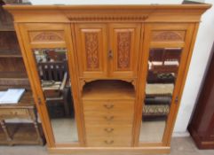 An Edwardian satin walnut triple wardrobe, with a moulded cornice above a pair of mirrored doors,