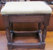 An oak stool with an upholstered top