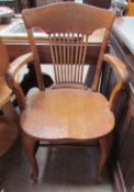 An oak captain's chair with a spindle back and arms open cabriole front legs