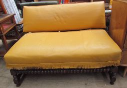 An oak framed upholstered two seater settee with a folding back on turned legs and a barley twist