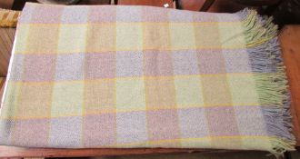 A wool blanket with a green and blue check pattern and fringe border