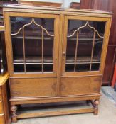 A 20th century oak display cabinet with a pair of glazed doors,
