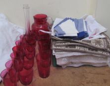 A cranberry glass jug together with cranberry glass glasses,