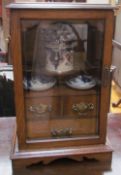 An oak cased smokers cabinet with a rectangular moulded top above a glazed doors fitted with