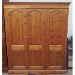 A modern pine triple wardrobe,