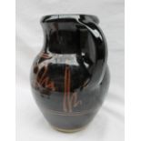 A large studio pottery jug, with a dark brown glaze with light brown decoration,