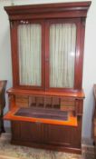 A late Victorian mahogany bookcase, the moulded cornice above a pair of glazed doors,