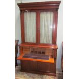 A late Victorian mahogany bookcase, the moulded cornice above a pair of glazed doors,