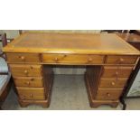 A Victorian style pine pedestal desk with a leather inset top above two banks of drawers on bracket