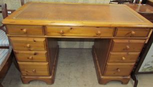 A Victorian style pine pedestal desk with a leather inset top above two banks of drawers on bracket