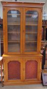 An Edwardian oak bookcase, the moulded cornice above a pair of glazed doors,