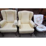 A pair of upholstered wing back arm chairs together with a mid 20th century upholstered chair