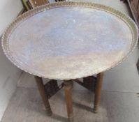 A brass tray top table with a Celtic pattern on a folding base together with a copper picture,