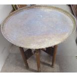 A brass tray top table with a Celtic pattern on a folding base together with a copper picture,