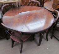 A Victorian mahogany extending dining table on four reeded legs together with a set of four