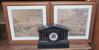 A black slate mantle clock of architectural form with three ionic columns,