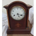 An Edwardian mahogany mantle clock, the domed top above a pair of ionic columns and a plinth base,