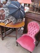 A Victorian style mahogany spoon back nursing chair together with two parasols and an umbrella