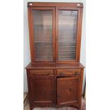 A 20th century oak bookcase with a moulded cornice above a pair of glazed doors,