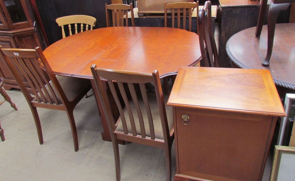A reproduction walnut gate leg dining table together with four chairs and a music cabinet